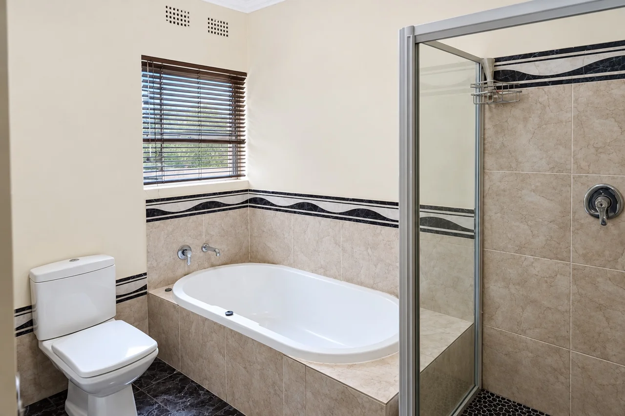 Bathroom with a bath, shower and basin at Cambridge House