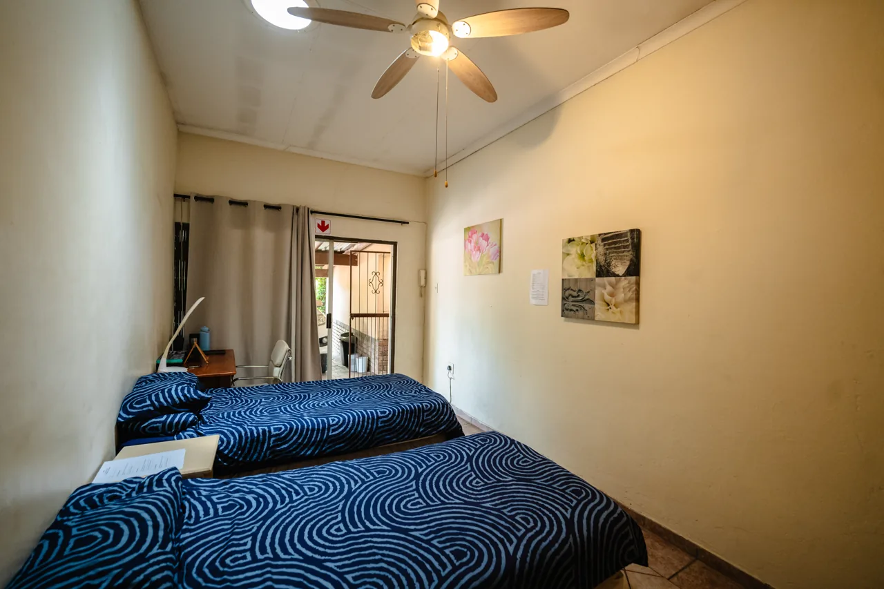 Two beds with blue bedding in a shared room at Cambridge House
