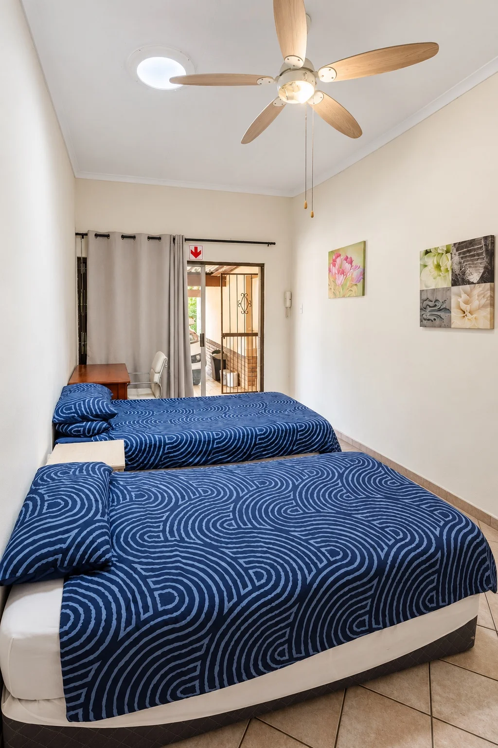 Two beds with blue bedding in a shared room at Cambridge House
